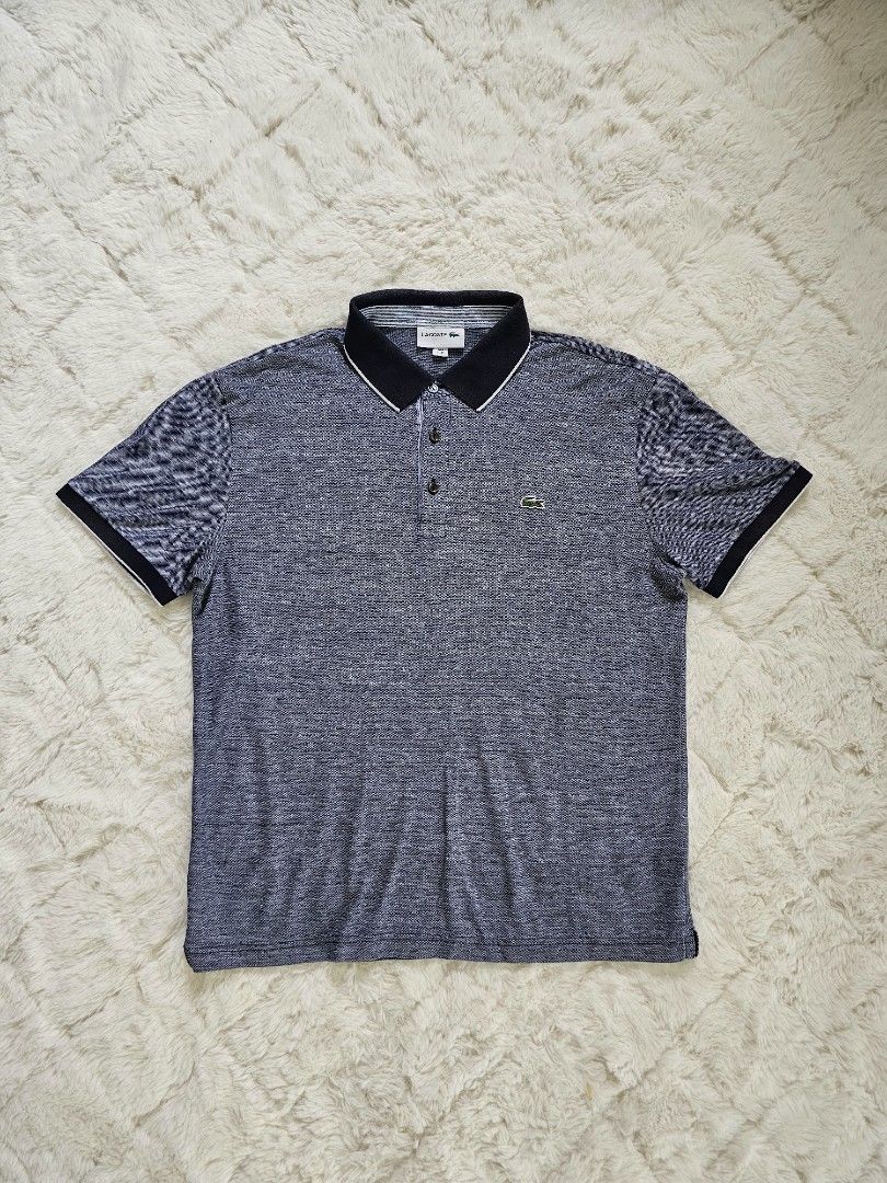Lacoste Polo Shirt - Navy Blue (Category: Tshirts & Polo Shirts ) located in Davao. Submitted by workwear_stuff (Listing ID 1396136303, Image 1). Description: Width 21 Length 26 issue Collar not visivle pgsuot na - Navy blue Lacoste polo shirt - Size: M - Classic collar with white trim - Features the iconic Lacoste logo - Textured pattern - Short sleeves with contrasting black and white cuffs.