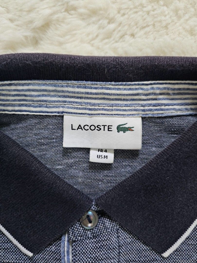 Lacoste Polo Shirt - Navy Blue (Category: Tshirts & Polo Shirts ) located in Davao. Submitted by workwear_stuff (Listing ID 1396136303, Image 3). Description: Width 21 Length 26 issue Collar not visivle pgsuot na - Navy blue Lacoste polo shirt - Size: M - Classic collar with white trim - Features the iconic Lacoste logo - Textured pattern - Short sleeves with contrasting black and white cuffs.