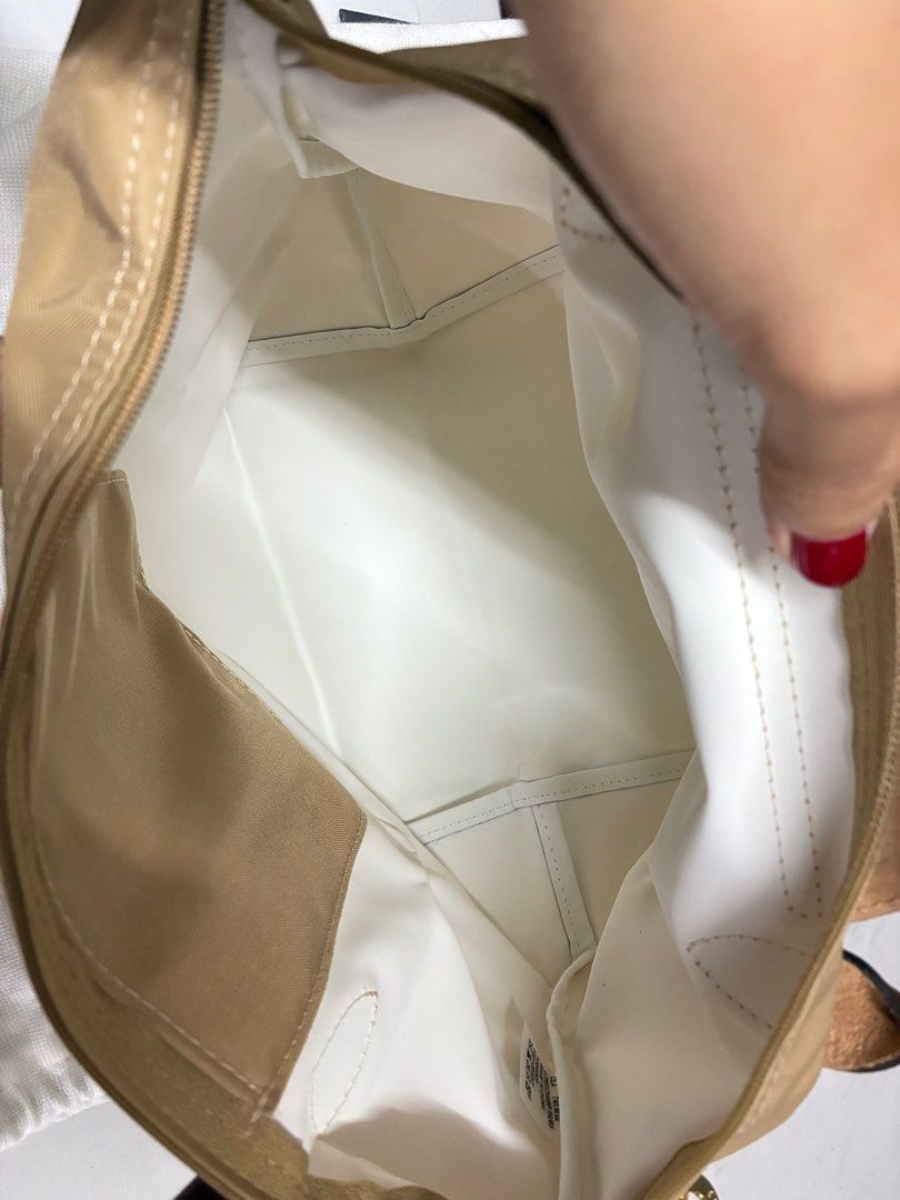 Longchamp Le Pliage Handbag (Category: Luxury Bags & Wallets) located in Manila. Submitted by thrifters.mnl.28 (Listing ID 1396111754, Image 3). Description: - Authentic Longchamp Le Pliage - Tan nylon exterior - Brown leather handles and accents - White interior - Includes Longchamp dust bag - Features Longchamp logo on zipper pull - Made in China.