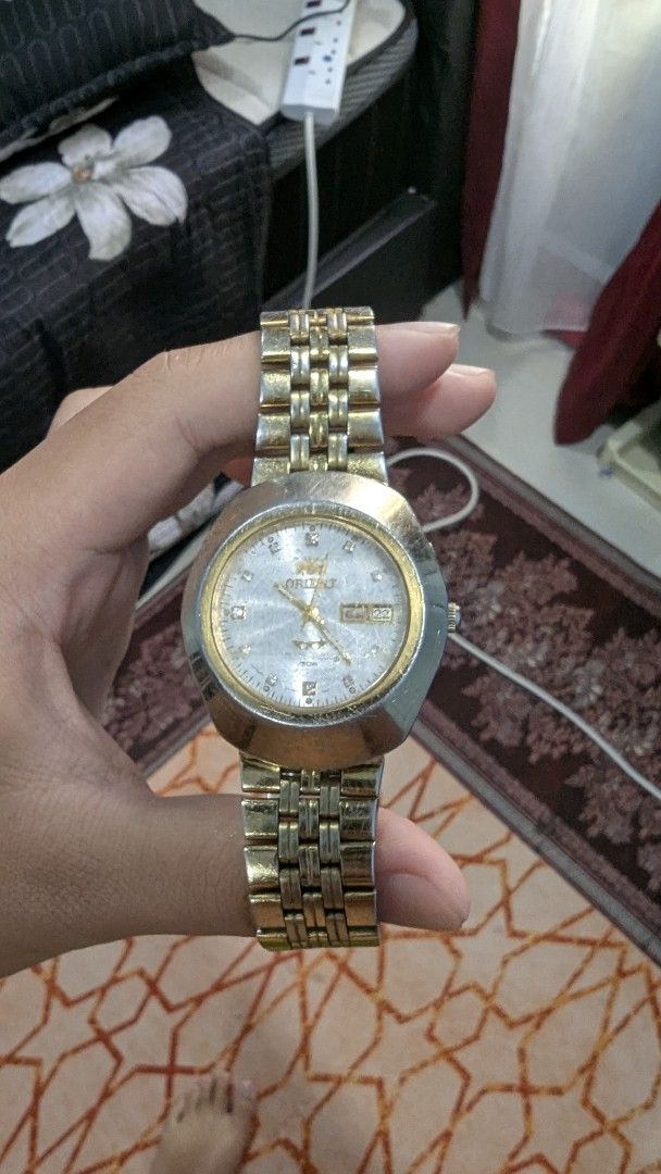 Orient Automatic Watch (Category: Watches) located in Cherang Ruku. Submitted by ashraappp.store (Listing ID 1396200315, Image 2). Description: - Vintage Orient automatic watch - Gold and silver-tone bracelet - Day and date display - Orient logo and model information on the back.
