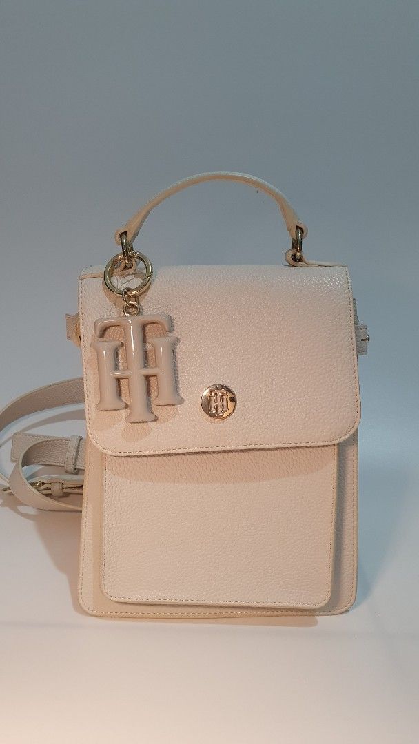 Tommy Hilfiger Convertible Handbag (Category: Luxury Bags & Wallets) located in Cabanatuan. Submitted by nix.cynn (Listing ID 1396207218, Image 1). Description: - never used - Cream-colored Tommy Hilfiger handbag - Top handle and detachable shoulder strap (crossbody/backpack) - Flap closure with gold-tone logo - Interior zippered pocket - Gold-tone hardware - Textured exterior.