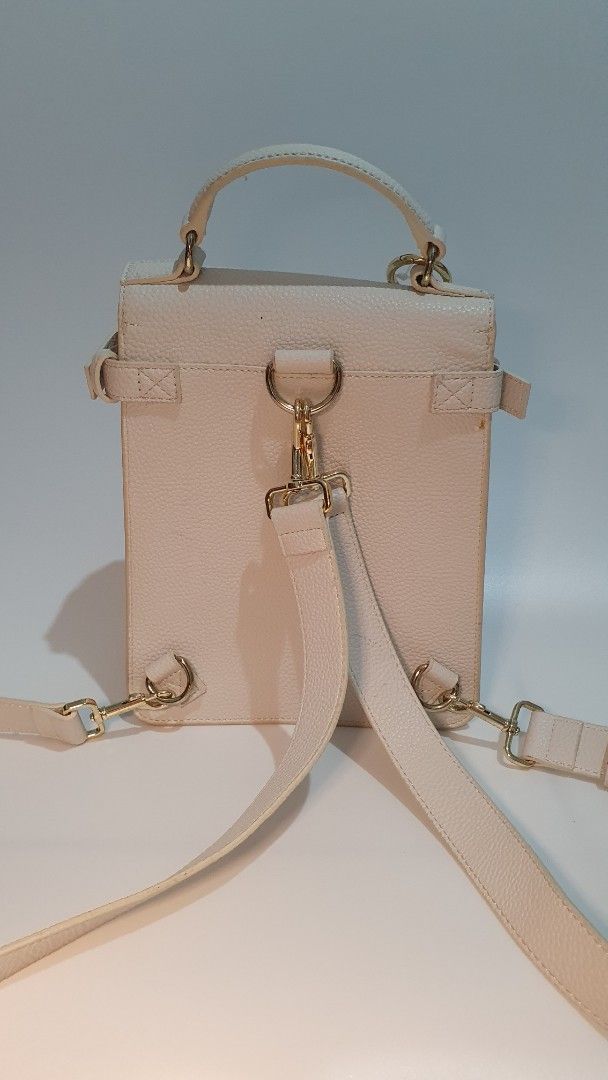 Tommy Hilfiger Convertible Handbag (Category: Luxury Bags & Wallets) located in Cabanatuan. Submitted by nix.cynn (Listing ID 1396207218, Image 3). Description: - never used - Cream-colored Tommy Hilfiger handbag - Top handle and detachable shoulder strap (crossbody/backpack) - Flap closure with gold-tone logo - Interior zippered pocket - Gold-tone hardware - Textured exterior.