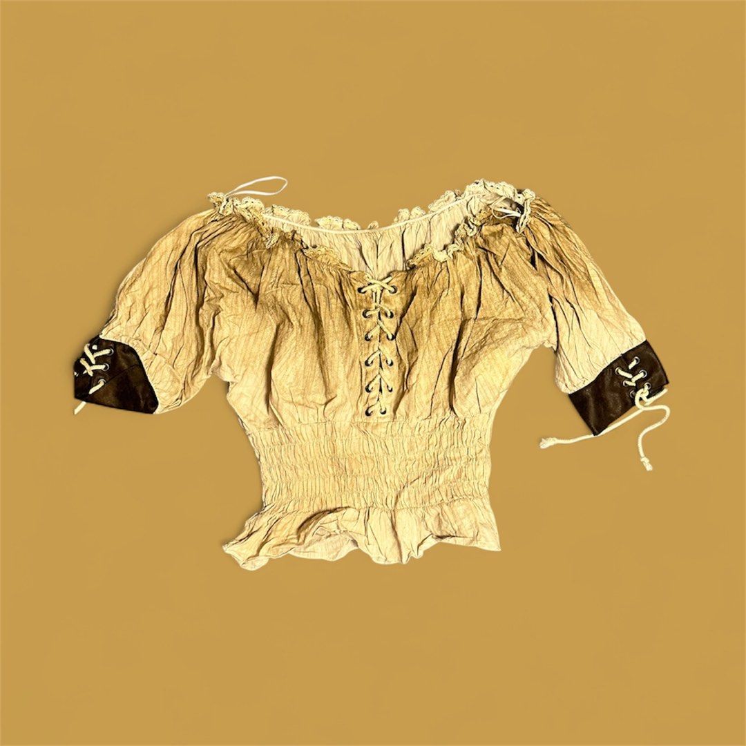 Vintage Style Lace-Up Blouse (Category: Blouses) located in Baguio. Submitted by ons03 (Listing ID 1396177167, Image 1). Description: - Vintage-inspired blouse - Lace-up front - Short sleeves with dark brown cuffs - Gathered waist and neckline - Textured fabric - Light beige color - Unique tie details on sleeves.