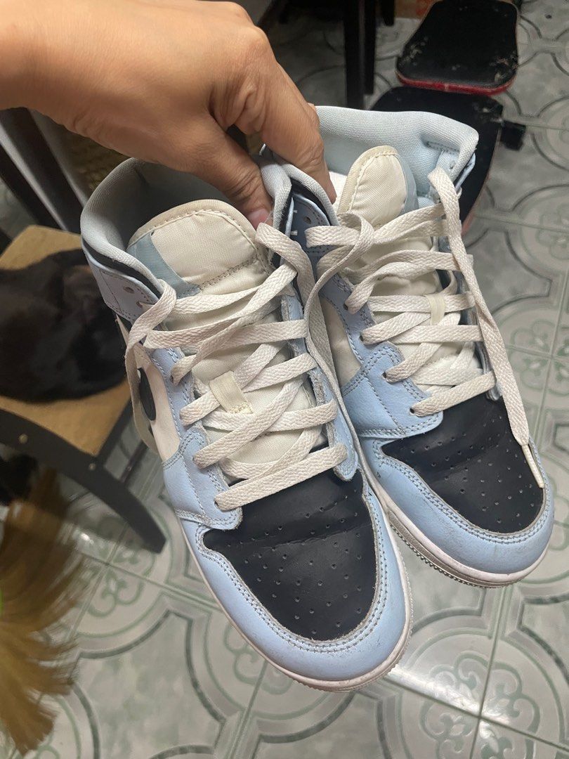 Air Jordan 1 Mid Light Blue Black (Category: Sneakers) located in Pasig City. Submitted by kyla792980 (Listing ID 1401219575, Image 3). Description: Air Jordan 1 Mid in a light blue, black, and white colorway. Features the iconic Air Jordan wings logo on the side. The size is US 6.5Y. The shoes have white laces and a light blue and black design. The sole is white. kasya po sa 7.5 wms size.. declutter:) nabili ko sya sa footlcker sg.