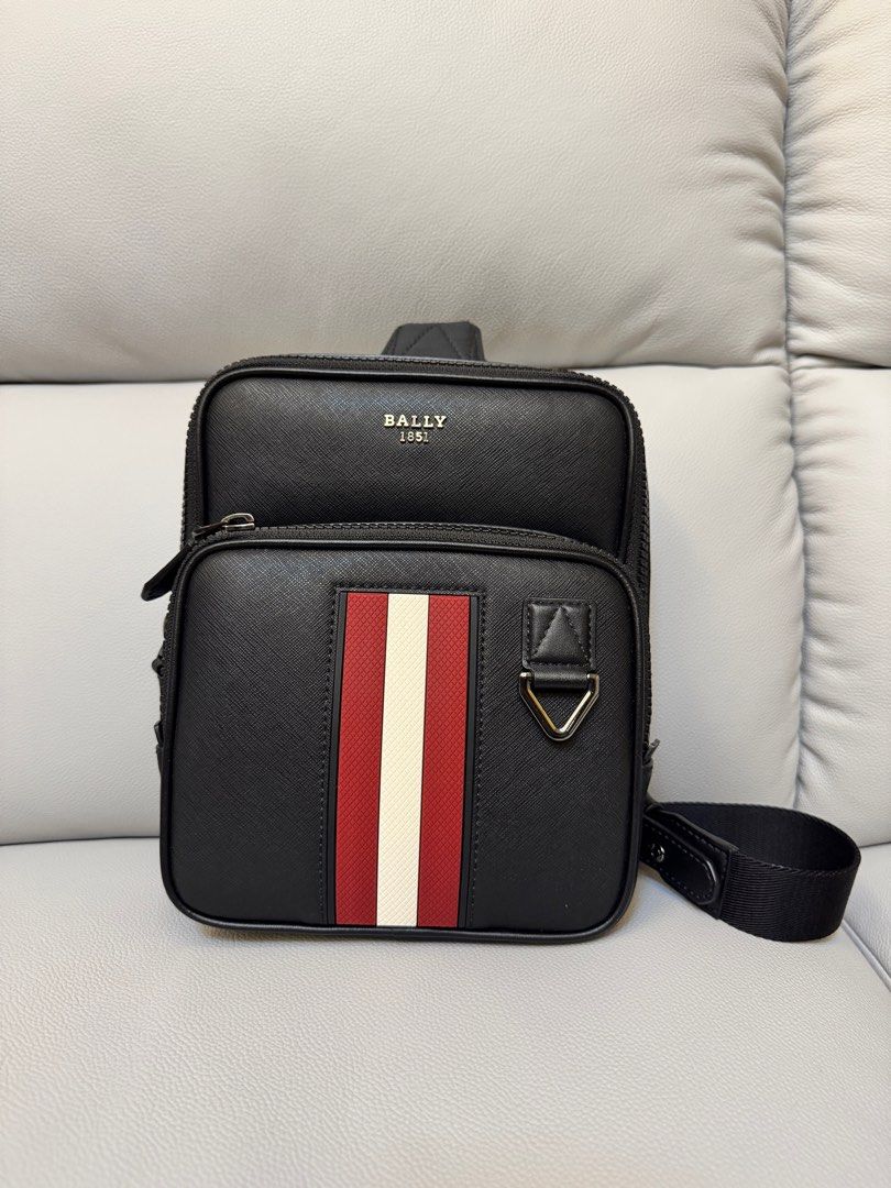 Bally Sling Bag with Stripe Detail (Category: Luxury Bags & Wallets) located in Manila. Submitted by ml0626 (Listing ID 1401298305, Image 1). Description: - Black Bally sling bag - Front compartment with red and white stripe - Top zip compartment - Adjustable shoulder strap - Bally logo embossed on top - Textured material Meet up only, item too expensive to ship.