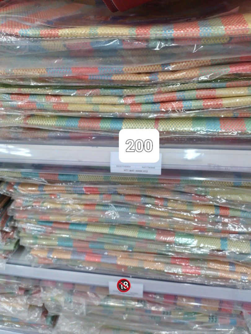 Banig Mats (Category: Carpets, Mats & Flooring) located in Caloocan City. Submitted by teacherjen53235 (Listing ID 1401169448, Image 2). Description: These mats feature a vibrant striped design in various colors. They are available in different price points: ₱350, ₱250, and ₱200. The mats appear to be new and are still in their original packaging. They are suitable for various uses, such as picnics, beach outings, or home decor..