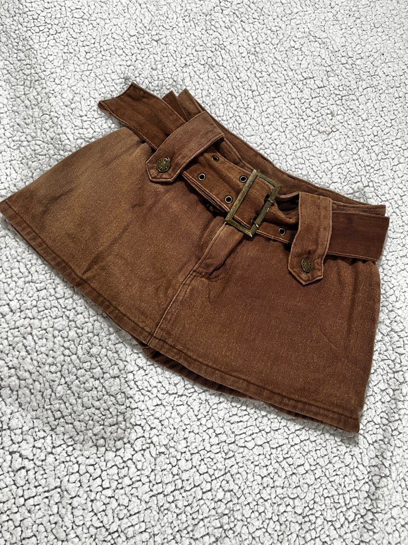 Brown Denim Skirt with Belt (Category: Skirts) located in San Fernando. Submitted by declutterbydani__ (Listing ID 1401283644, Image 1). Description: - Mini denim skirt - Matching belt included - Buckle closure - Denim fabric - Can fit 24-25.