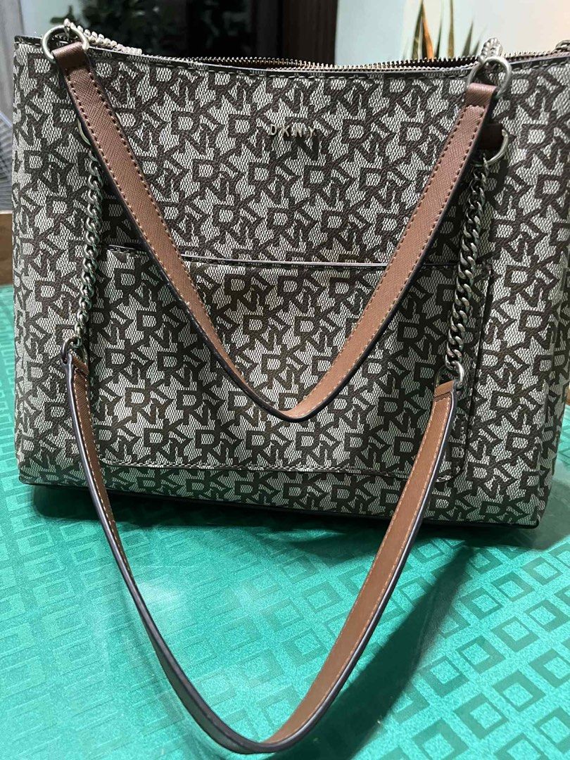DKNY Brown Tote Bag with Chain Straps (Category: Luxury Bags & Wallets) located in Malabon City. Submitted by levineabby (Listing ID 1401343018, Image 2). Description: - DKNY brown tote bag - Features DKNY logo pattern - Chain and leather straps - Exterior pocket - Zippered main compartment - Interior DKNY label - Shows wear on edges and zipper area.