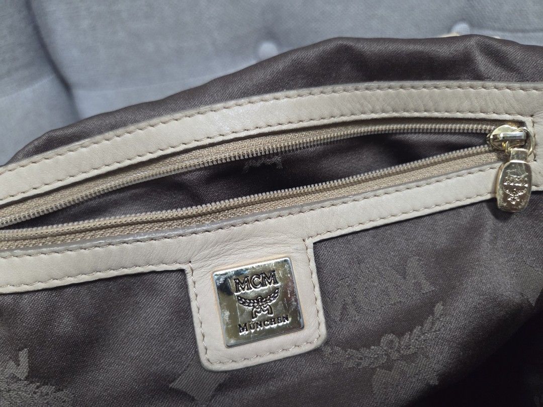 MCM Handbag (Category: Luxury Bags & Wallets) located in Muntinlupa City. Submitted by cpar07 (Listing ID 1401263300, Image 3). Description: - Authentic MCM handbag - Signature logo pattern - Beige exterior - Shoulder bag style - Matching handle with satin-like finish - Interior zipper pocket - Includes brand tag.