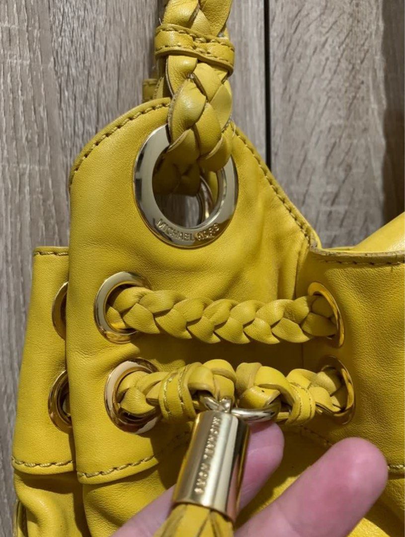 Michael Kors Yellow Braided Handle Handbag (Category: Luxury Bags & Wallets) located in San Pedro. Submitted by twinklestreasures (Listing ID 1401285112, Image 3). Description: - Authentic Michael Kors handbag - Color: Yellow - Features braided handles - Drawstring closure - Gold-tone hardware - Tassel detail - Exterior pockets - Spacious interior - Gold studs on the bottom.