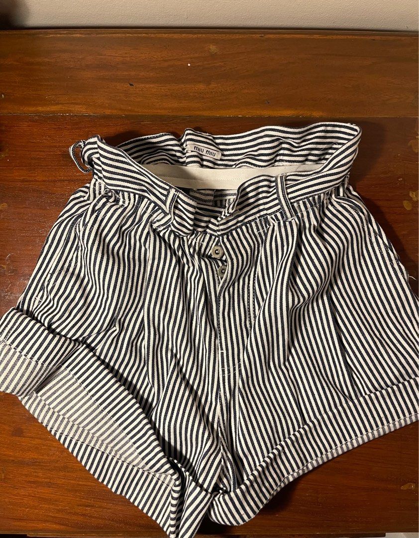 Miu Miu Striped Shorts (Category: Shorts) located in Quezon City. Submitted by d.archives (Listing ID 1401191242, Image 1). Description: Stylish Miu Miu shorts featuring a striped pattern. These shorts have a high-waisted design with a button closure and a belt loop. The back of the shorts has a small logo patch. The shorts have rolled-up cuffs. Perfect for a casual yet chic look..