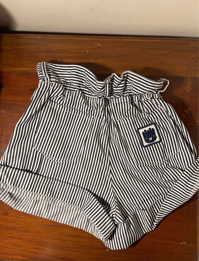 Miu Miu Striped Shorts (Category: Shorts) located in Quezon City. Submitted by d.archives (Listing ID 1401191242, Image 2). Description: Stylish Miu Miu shorts featuring a striped pattern. These shorts have a high-waisted design with a button closure and a belt loop. The back of the shorts has a small logo patch. The shorts have rolled-up cuffs. Perfect for a casual yet chic look..