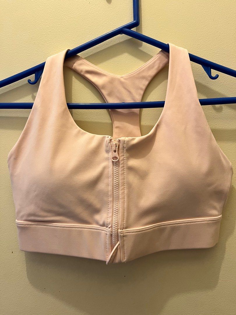 Pink Zip-Front Sports Bra (Category: Activewear) located in Taguig. Submitted by hhhhhrttte (Listing ID 1401333726, Image 1). Description: - Light pink sports bra - Front zipper - Racerback design - Wide bottom band - Shown on a blue hanger RFS need funds.