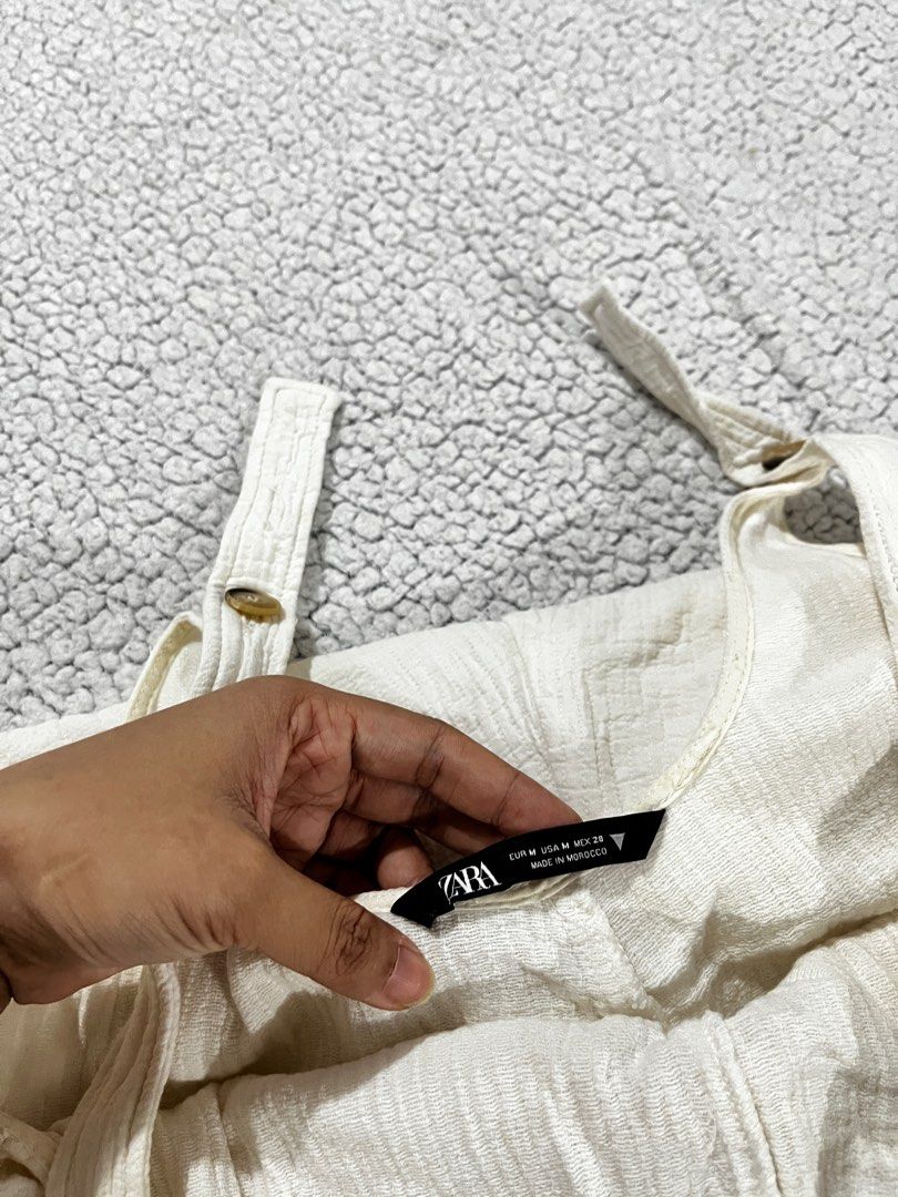 Zara White Romper (Category: Rompers) located in San Fernando. Submitted by declutterbydani__ (Listing ID 1401285679, Image 2). Description: - Zara white romper - Size M - Adjustable straps - Button details - Features pockets - Linen Fabric -Never been used.