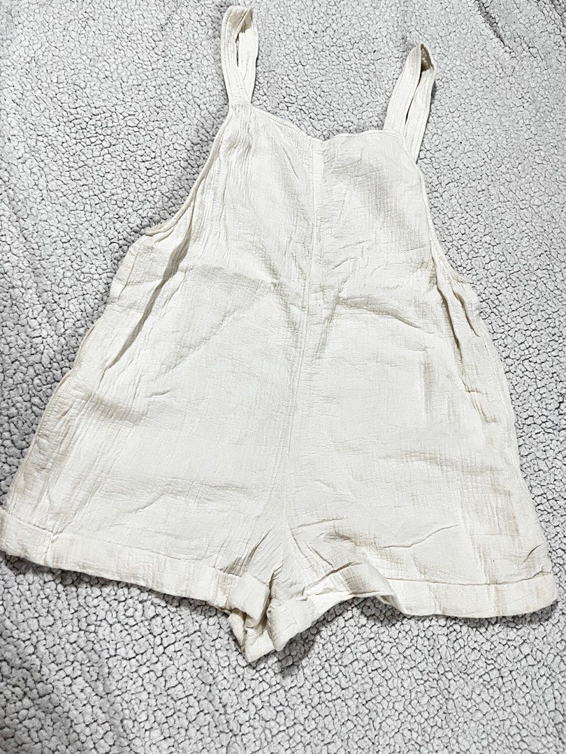 Zara White Romper (Category: Rompers) located in San Fernando. Submitted by declutterbydani__ (Listing ID 1401285679, Image 1). Description: - Zara white romper - Size M - Adjustable straps - Button details - Features pockets - Linen Fabric -Never been used.
