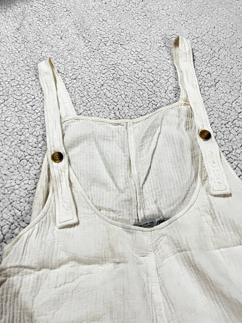 Zara White Romper (Category: Rompers) located in San Fernando. Submitted by declutterbydani__ (Listing ID 1401285679, Image 3). Description: - Zara white romper - Size M - Adjustable straps - Button details - Features pockets - Linen Fabric -Never been used.