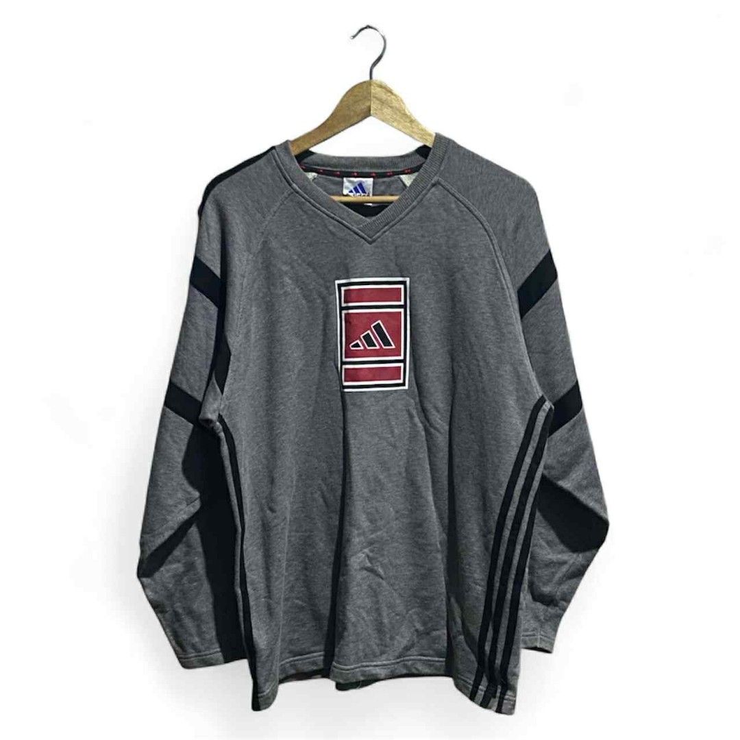 Adidas V-Neck Sweatshirt XL (Category: Coats, Jackets and Outerwear) located in Manila. Submitted by aurafits (Listing ID 1401530025, Image 1). Description: Vintage Adidas sweatshirt in gray with black and red accents. Features the Adidas logo on the front and sleeves. It has a V-neck design and is size XL. The sweatshirt has the classic three stripes on the sleeves. The back of the sweatshirt is plain gray. No issue excellent condition Dimes: 23