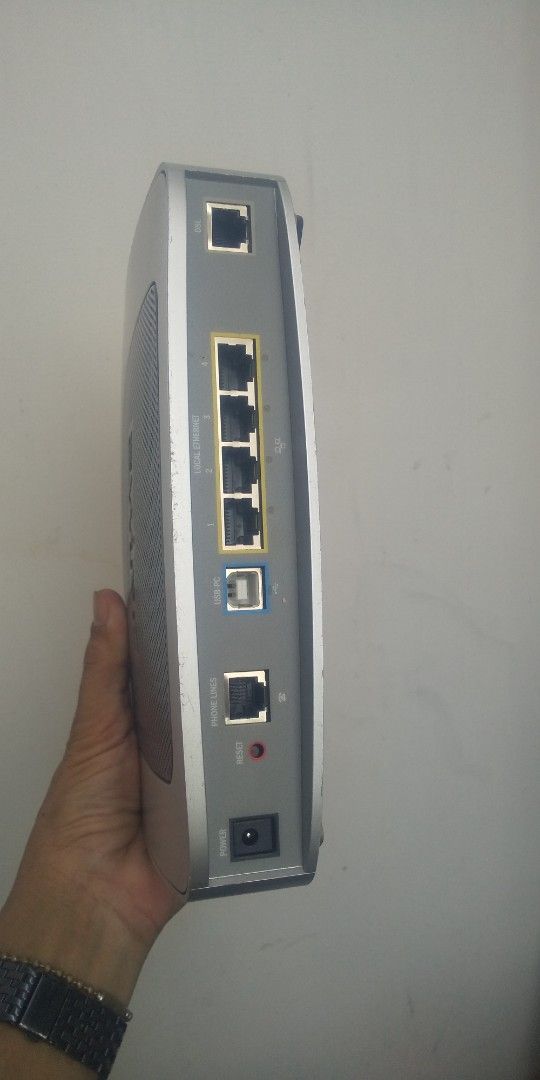 BT Broadband Router (Category: Networking) located in Carmona. Submitted by rpute (Listing ID 1401367039, Image 3). Description: - BT 3700HGV Router - Silver and black design - Multiple ports: Ethernet, USB - Power button - Indicator lights - 'ewire' logo - Power input.