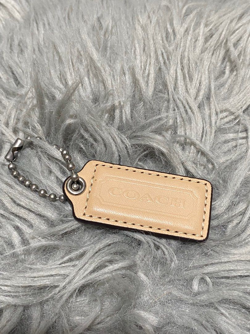 Coach Leather Keychain Tag (Category: Shoulder Bags) located in Balanga. Submitted by vintagefanatics (Listing ID 1401363091, Image 1). Description: Coach keychain tag. Beige leather with embossed logo. Silver-tone chain. Rectangular shape..