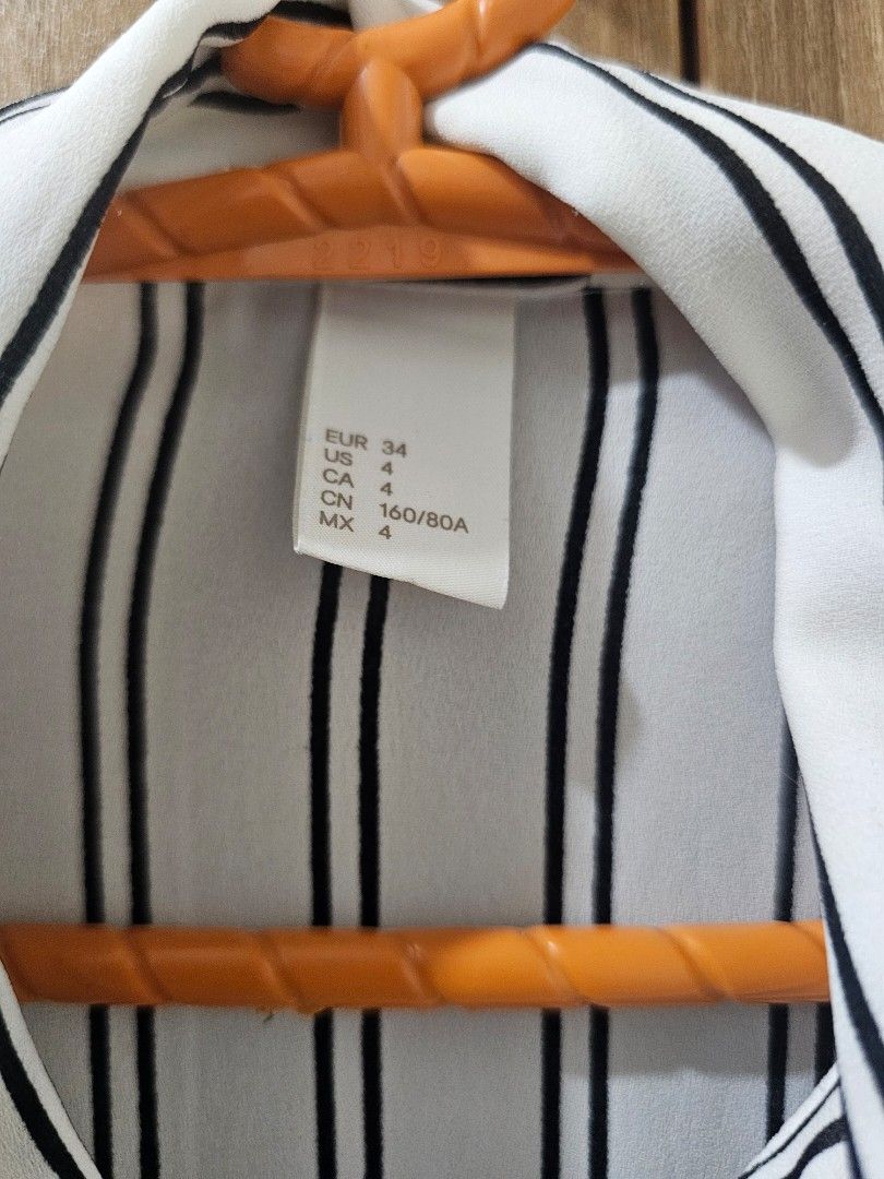 H&M White Striped Blouse (Category: Blouses) located in Quezon City. Submitted by jddss (Listing ID 1401431820, Image 3). Description: H&M White blouse with black stripes - Long sleeves - Collared neckline - Button-down front - Size 4 (pwede rin for XS for oversized look) - Lightweight material, needs inner shirt when worn - Issues: Small mark and run sa likod (kindly see last 2 photos) - Really cute in person, pwede pang-tita look - Personal fav