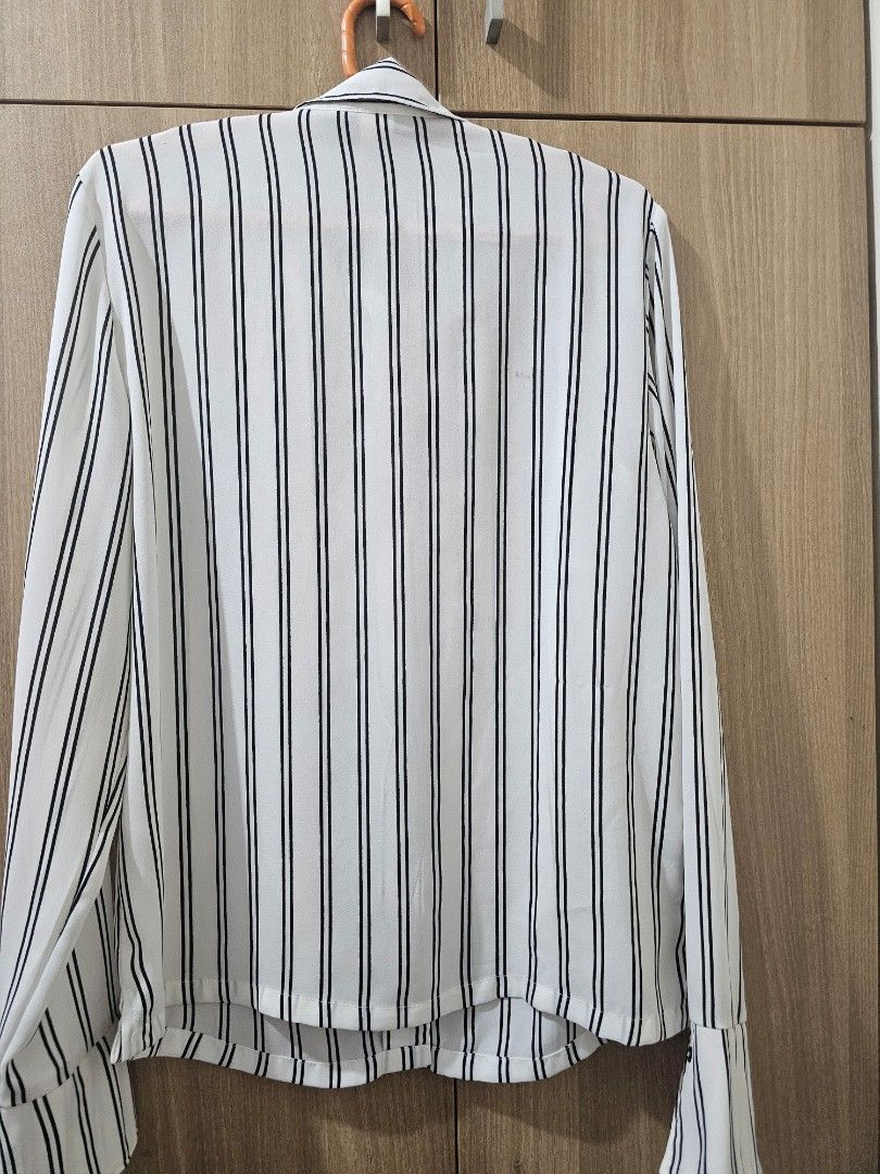 H&M White Striped Blouse (Category: Blouses) located in Quezon City. Submitted by jddss (Listing ID 1401431820, Image 2). Description: H&M White blouse with black stripes - Long sleeves - Collared neckline - Button-down front - Size 4 (pwede rin for XS for oversized look) - Lightweight material, needs inner shirt when worn - Issues: Small mark and run sa likod (kindly see last 2 photos) - Really cute in person, pwede pang-tita look - Personal fav