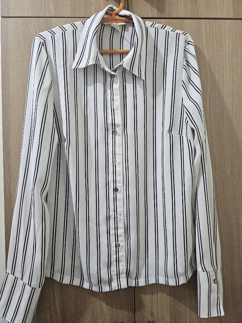 H&M White Striped Blouse (Category: Blouses) located in Quezon City. Submitted by jddss (Listing ID 1401431820, Image 1). Description: H&M White blouse with black stripes - Long sleeves - Collared neckline - Button-down front - Size 4 (pwede rin for XS for oversized look) - Lightweight material, needs inner shirt when worn - Issues: Small mark and run sa likod (kindly see last 2 photos) - Really cute in person, pwede pang-tita look - Personal fav