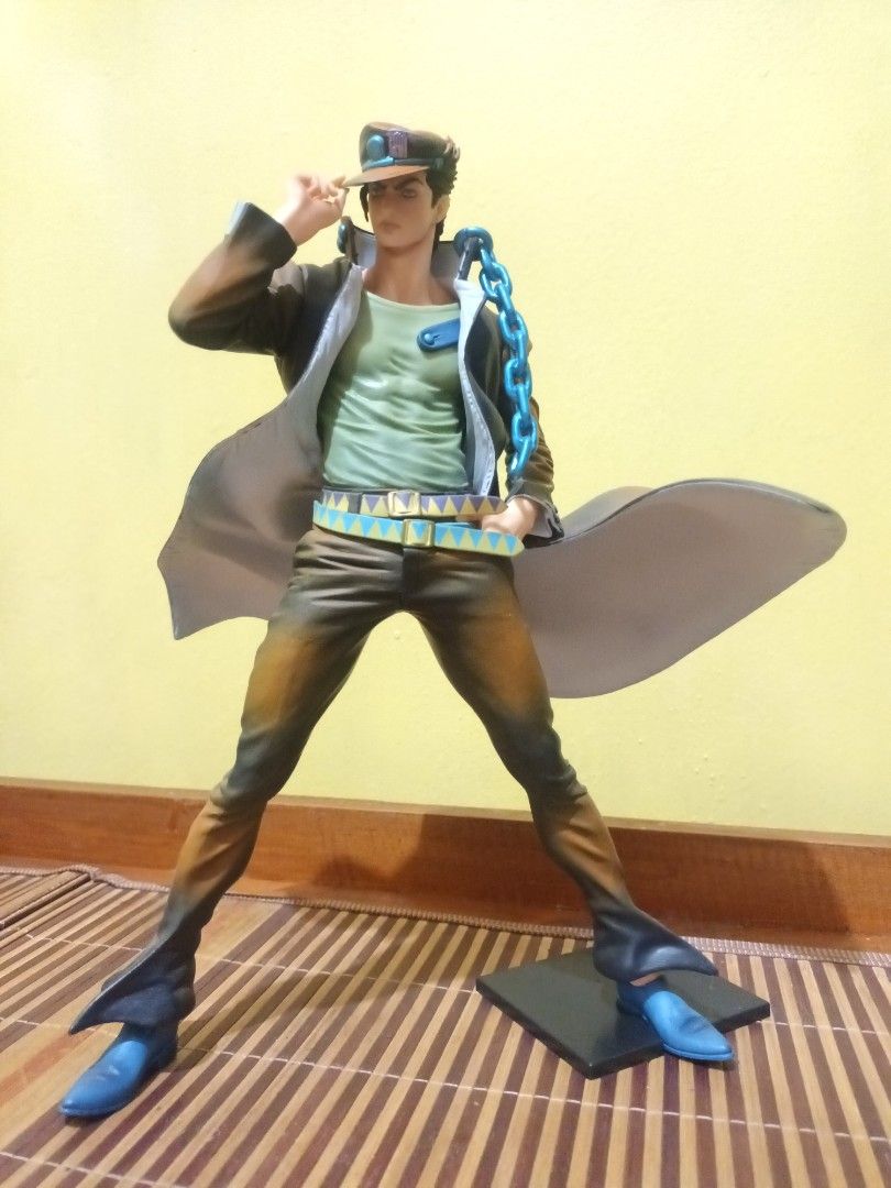 Jojo's Bizarre Jotaro Kujo (Category: Figurines & Statues) located in Bacarra. Submitted by acobasherw74134 (Listing ID 1401359948, Image 2). Description: - Jojo's Bizarre Adventure figure - Dynamic pose - Detailed outfit - Character with hat, sunglasses, and chain - Color scheme: Brown, blue, and green - Includes base -Loose.