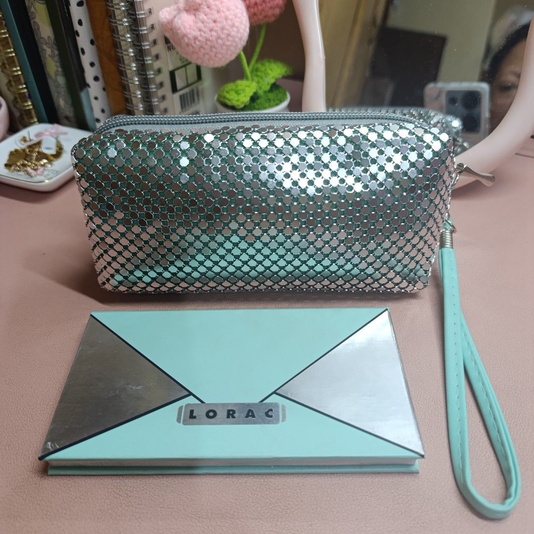 LORAC Eyeshadow Palette and Silver Pouch (Category: Makeup) located in Las Pinas. Submitted by min_yanna (Listing ID 1401357020, Image 1). Description: Set includes a LORAC eyeshadow palette and a silver mesh pouch. The palette features a variety of eyeshadow shades and a mirror. The pouch has a zipper closure and a wrist strap. The interior of the pouch is a light green color. The palette is in its original packaging. .
