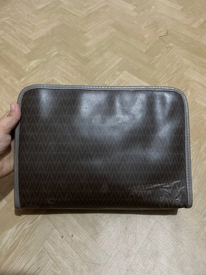 Mario Valentino Clutch Bag (Category: Luxury Bags & Wallets) located in Santiago. Submitted by luxuryfindforlessph (Listing ID 1401359807, Image 2). Description: - Mario Valentino clutch bag - Brown patterned exterior with gray trim - Gold-tone zipper closure - Gold-tone Mario Valentino logo - Made in Italy - Signs of wear on corners and edges.