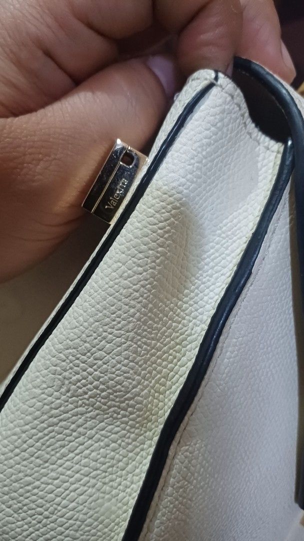 Valextra Handbag with Shoulder Strap (Category: Luxury Bags & Wallets) located in Lemery. Submitted by venus23 (Listing ID 1401483993, Image 2). Description: Elegant handbag with detachable strap. Features flap closure, gold clasp, and zippered pocket. Light color with black trim..