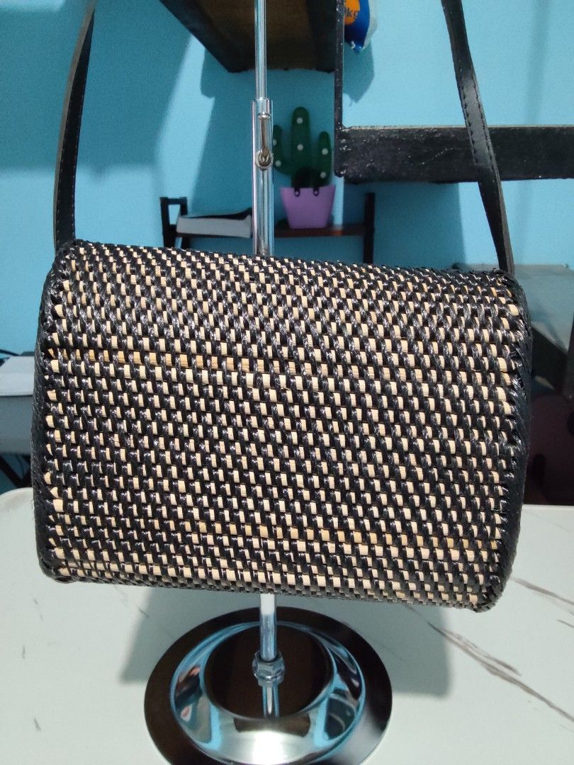 Woven Crossbody Bag with Batik Lining (Category: Cross-body Bags) located in Pasig City. Submitted by zealfish.3d4f32 (Listing ID 1401424912, Image 3). Description: - Woven crossbody bag in black and beige - Features a flap closure with a leather strap - Decorative trim - Lined with colorful batik fabric - Includes a long, adjustable strap - Ideal for everyday wear.