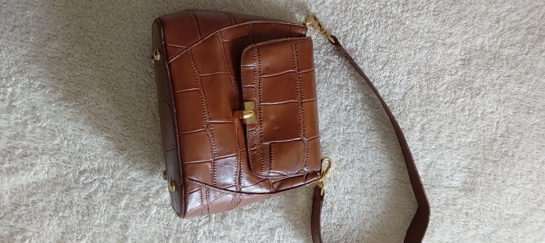 Brown Crocodile-Embossed Handbag (Category: Luxury Bags & Wallets) located in San Fernando. Submitted by rizdgr (Listing ID 1396297022, Image 2). Description: - Brown handbag with crocodile-embossed design - Gold-tone clasp and hardware - Includes shoulder strap - Classic and stylish accessory Ship fee c/o buyer Pm me.