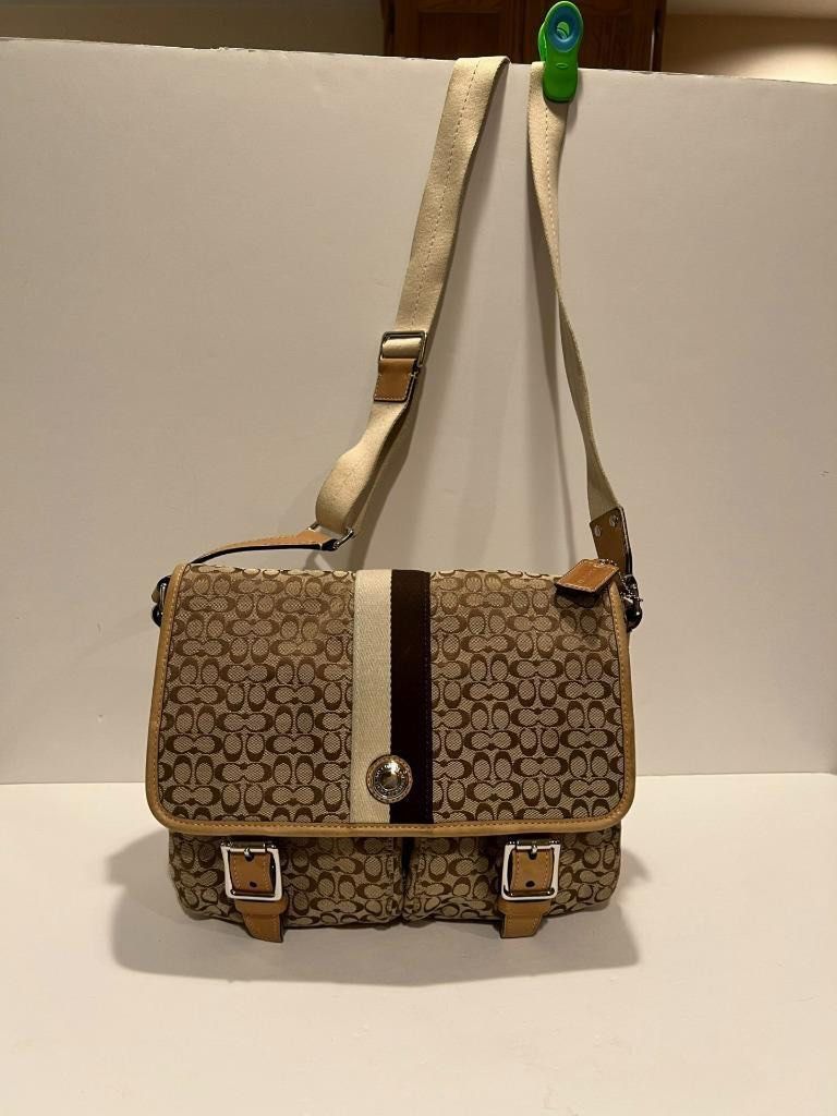 Coach Voyager Messenger Bag School Bag (Category: Luxury Bags & Wallets) located in Quezon City. Submitted by louiesaaa (Listing ID 1396455615, Image 2). Description: -Good as new - Brown and beige monogram pattern - Central stripe detail - Two front pockets with buckle closures - Coach logo emblem .