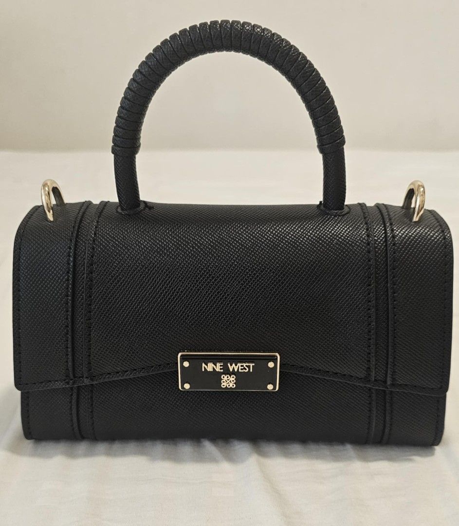 Nine West Black Handbag with Top Handle (Category: Luxury Bags & Wallets) located in Manila. Submitted by bry_d (Listing ID 1396459068, Image 2). Description: - Nine West handbag - Structured design - Top handle and detachable shoulder strap - Rectangular shape with flap closure - Features a small metal logo - Includes dust bag - Gold-toned hardware.