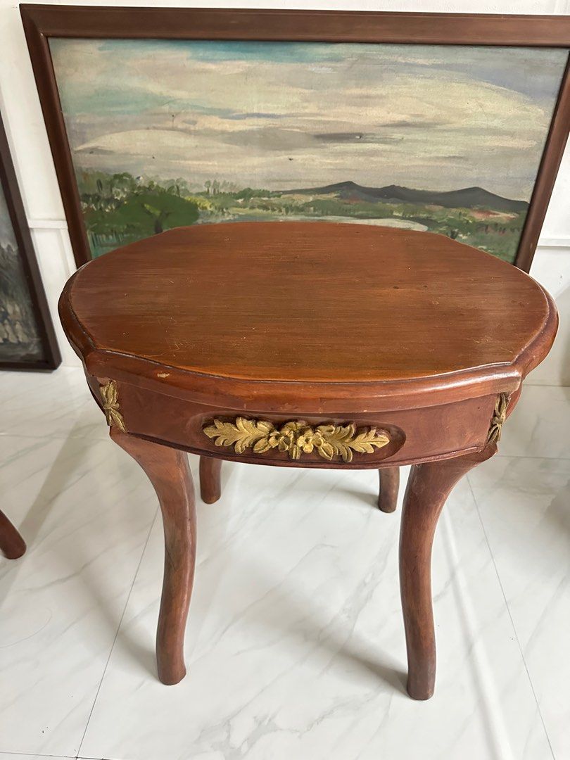 Vintage Narra side table pair (Category: Tables & Sets) located in Quezon City. Submitted by anjherga27 (Listing ID 1396339668, Image 2). Description: - Set of two vintage side tables - Wooden construction - Unique shapes with curved legs - Decorative gold accents - Rich brown tabletops - Perfect for decor or drinks - Charming addition to any living space.