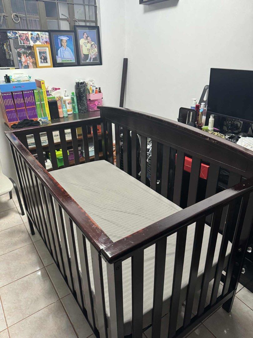 Wooden Baby Crib (Category: Cots & Cribs) located in Manila. Submitted by mimarias (Listing ID 1396345180, Image 2). Description: - Dark brown wooden baby crib - Includes mattress with grey sheet - Slatted sides and curved headboard - Sturdy and well-constructed - Perfect for babies and toddlers.