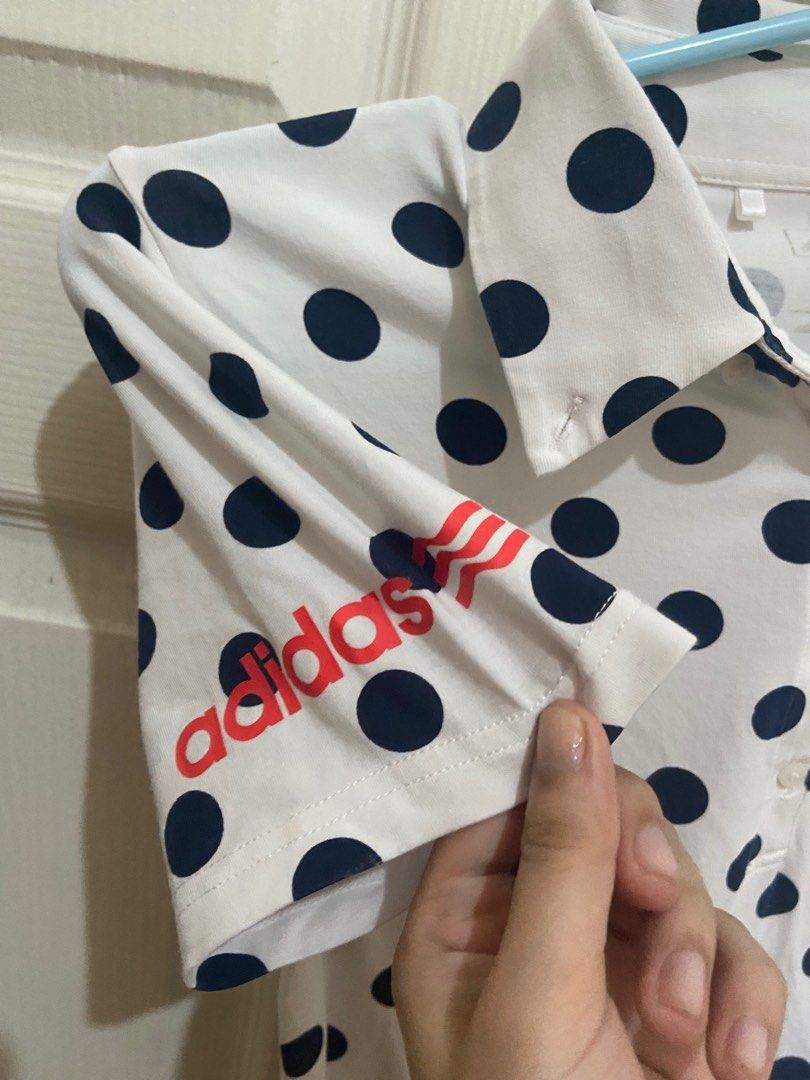 Adidas Polka Dot Polo Shirt (Category: Tshirts & Polo Shirts ) located in Antipolo. Submitted by declutteringtomorrow (Listing ID 1396478706, Image 3). Description: - Adidas polo shirt - White base with navy blue polka dots - Collared neckline - Button-down front - Adidas logo on sleeve and chest - Lightweight material - Suitable for casual wear and sports.