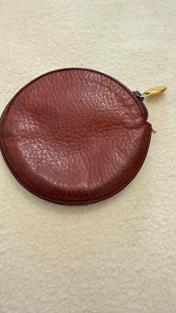 Cartier Round Coin Purse (Category: Luxury Bags & Wallets) located in Cavite. Submitted by rcmontoya (Listing ID 1396623797, Image 2). Description: - Authentic Cartier coin purse - Round shape - Deep reddish-brown textured leather - Gold-tone zipper pull - Embossed Cartier logo - Zipper closure - Small front pocket.