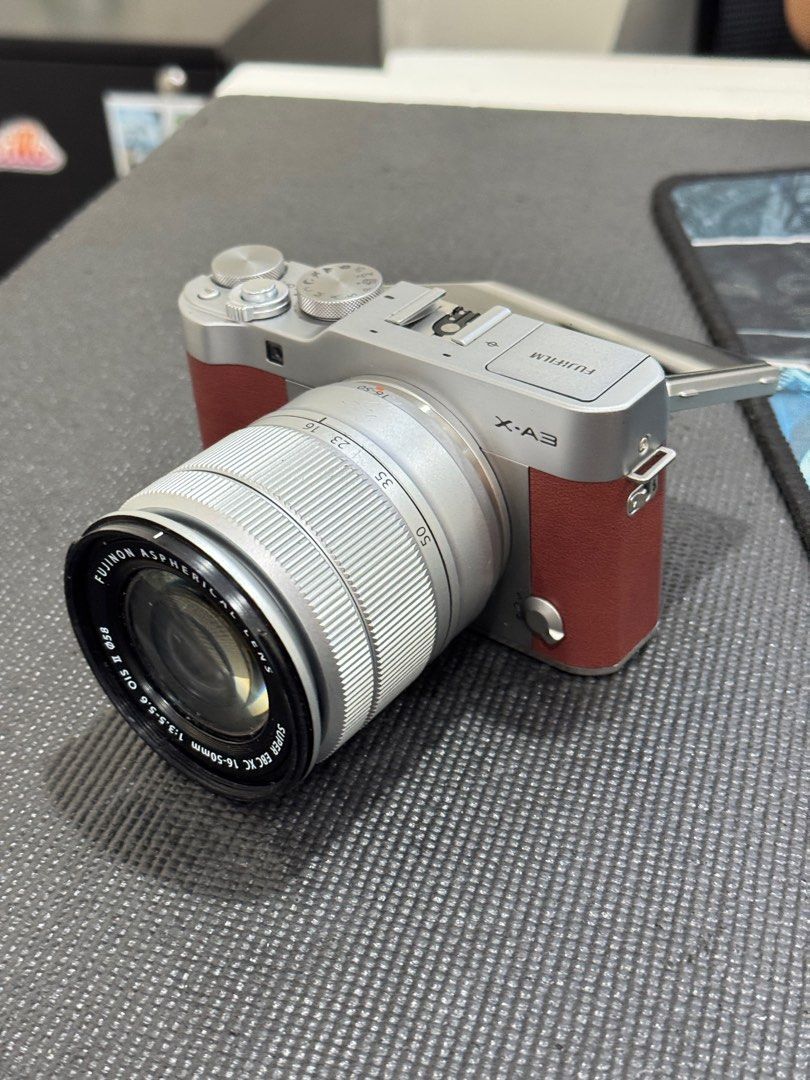 Fujifilm X-A3 Mirrorless Camera with Lens (Category: Cameras) located in Makati City. Submitted by nik.11 (Listing ID 1396527794, Image 1). Description: - Fujifilm X-A3 mirrorless camera - Includes XC 16-50mm f/3.5-5.6 OIS II lens - Silver body with brown accents - Camera shown at Fujifilm Service Center - Made in the Philippines - Includes camera body and lens.
