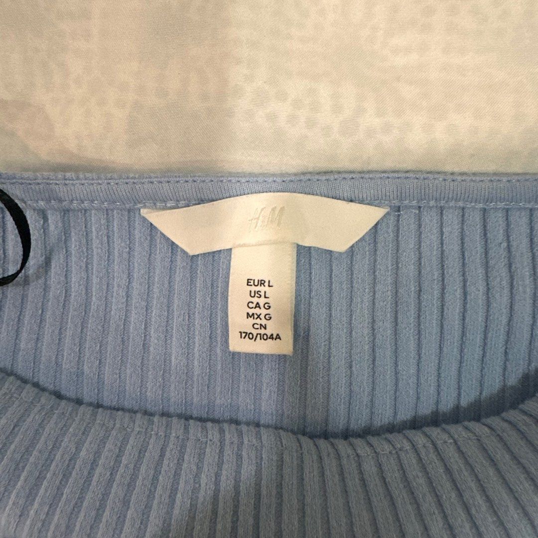 H&M Blue Ribbed Top with Puff Sleeves (Category: Blouses) located in Cainta. Submitted by moshiiicake (Listing ID 1396606691, Image 3). Description: - H&M top - Light blue ribbed fabric - Square neckline - Short puff sleeves - Cropped length - Size: L - Simple design, versatile for different outfits.