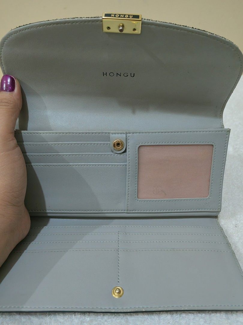 Hongu Navy Blue Wallet (Category: Luxury Bags & Wallets) located in Makati City. Submitted by prelovedtreatedwithlove (Listing ID 1396584643, Image 3). Description: - Navy blue Hongu wallet - Gold-tone clasp and logo - Multiple card slots - Clear ID window - Zippered compartment - Snap closure - Light gray interior with pink accent - Textured leather material -issue:may maliit na rubs last 2 pic for reference .