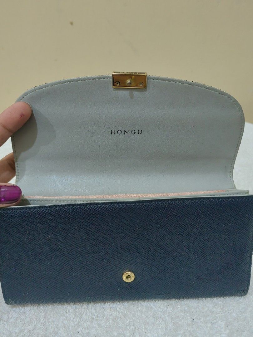 Hongu Navy Blue Wallet (Category: Luxury Bags & Wallets) located in Makati City. Submitted by prelovedtreatedwithlove (Listing ID 1396584643, Image 2). Description: - Navy blue Hongu wallet - Gold-tone clasp and logo - Multiple card slots - Clear ID window - Zippered compartment - Snap closure - Light gray interior with pink accent - Textured leather material -issue:may maliit na rubs last 2 pic for reference .