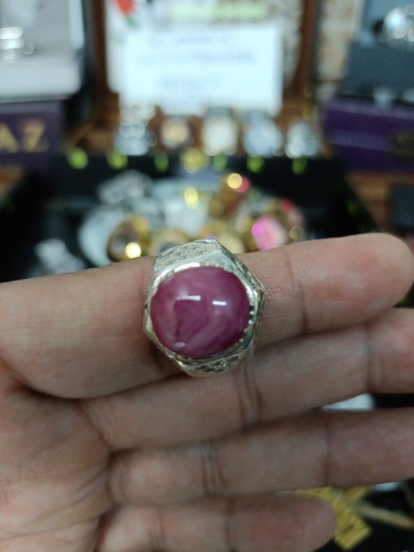 Ruby Gemstone Ring (Category: Accessories) located in Kota Bharu. Submitted by dzihnin8333 (Listing ID 1396657003, Image 1). Description: - Oval-shaped ruby gemstone - Set in a silver band - Intricate band detailing - Vibrant pinkish-red hue - Statement ring.