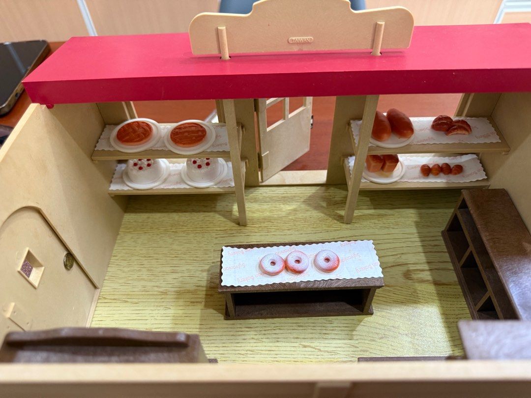 Sylvanian Families Bakery Boulangerie Playset (Category: Kids Toys) located in General Trias. Submitted by brightdog-224c (Listing ID 1396492637, Image 3). Description: - Sylvanian Families Bakery playset - Includes bakery building - Features shelves and counter - Comes with miniature cakes, bread, and donuts - Includes 'Open' sign and menu board - Comes with original box - Red roof and detailed interior.