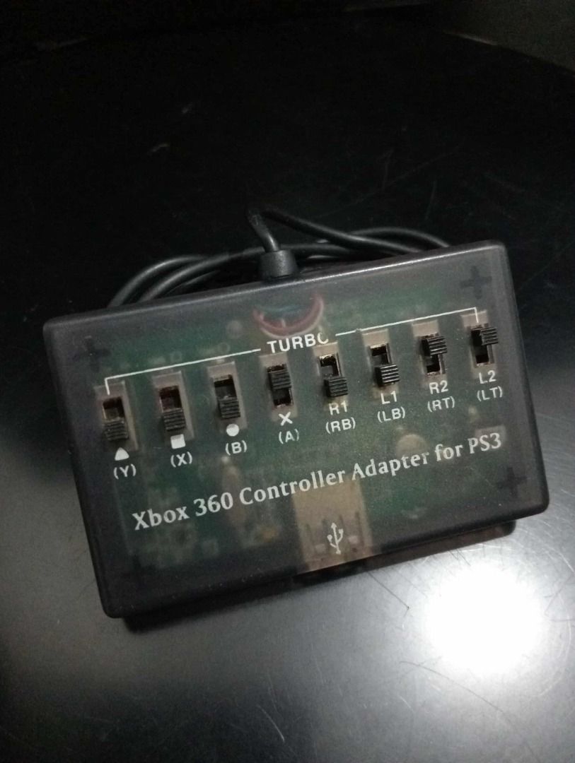 Xbox 360 Controller Adapter for PS3 (Category: Controllers) located in Quezon City. Submitted by potfishcake (Listing ID 1396517626, Image 1). Description: - Play your PS3 games with your Xbox 360 controller! - USB connection for easy setup. - Features button customization switches. - Includes a 'TURBO' setting for rapid-fire action. - Sleek black design with a clear plastic cover..