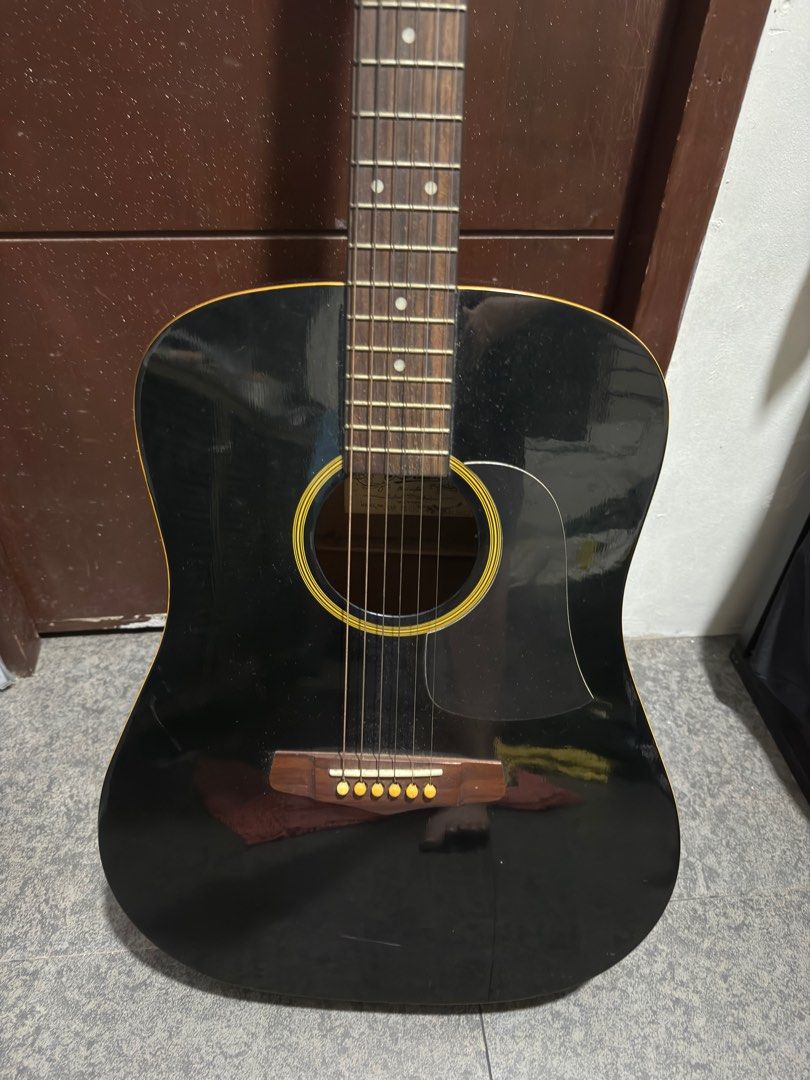 Aria Acoustic Guitar AW-75 BK (Category: Musical Instruments) located in Quezon City. Submitted by juanalamat19 (Listing ID 1396777324, Image 2). Description: - Aria AW-75 BK acoustic guitar - Black body with natural wood interior - Black headstock with Aria logo - Made in Korea - Includes six strings and tuning pegs - Features pickguard and sound hole.