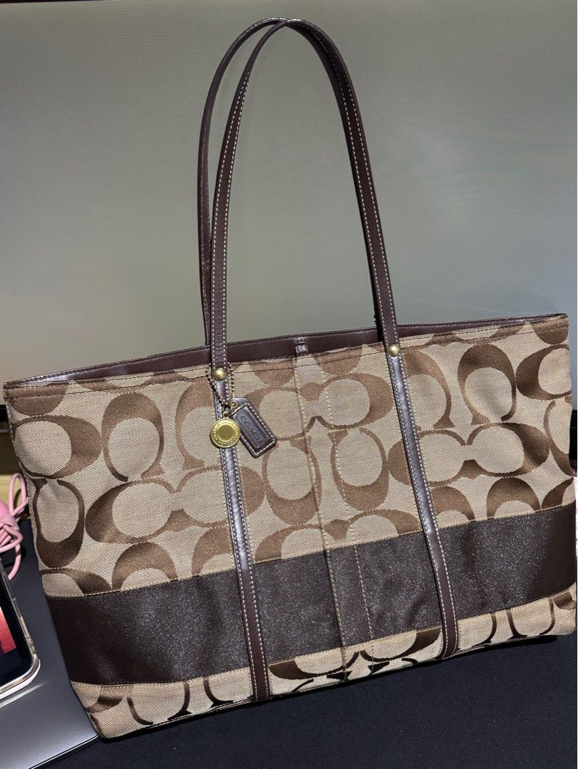 Coach Large Signature Tote Bag (Category: Luxury Bags & Wallets) located in Imus. Submitted by kacey19xxx (Listing ID 1396760419, Image 1). Description: - Coach tote bag - Signature brown print - Brown leather straps and trim - Includes Coach hangtag - Rectangular shape with spacious interior - Classic Coach pattern.