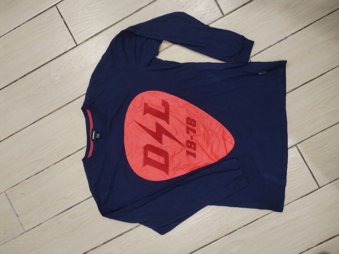 Diesel Long Sleeve Shirt (Category: Tshirts & Polo Shirts ) located in Manila. Submitted by dbadd (Listing ID 1396681857, Image 1). Description: - Navy blue long sleeve shirt - Features a red graphic with "DSL 19-78" - Crew neck with pink trim - Diesel logo visible.