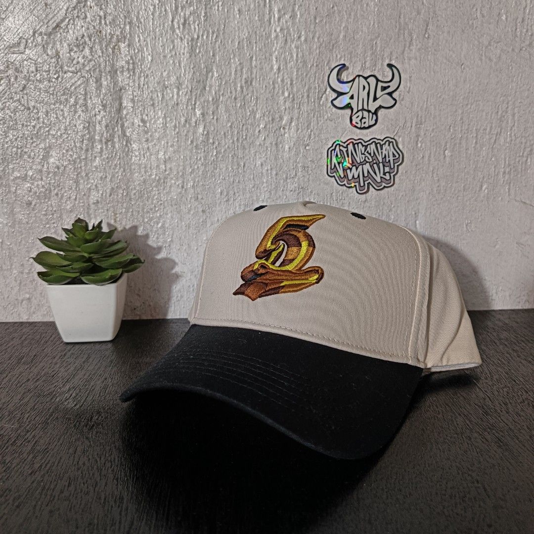 Dreamville Festival Cap (Category: Caps & Hats) located in Quezon City. Submitted by Hatlits (Listing ID 1396705362, Image 1). Description: - Dreamville Festival cap - Beige crown, black brim - Dreamville logo embroidered on the back - Stylized "2" on the front - Snapback closure (adjustable sizing) - Dreamville Festival branding on interior lining.