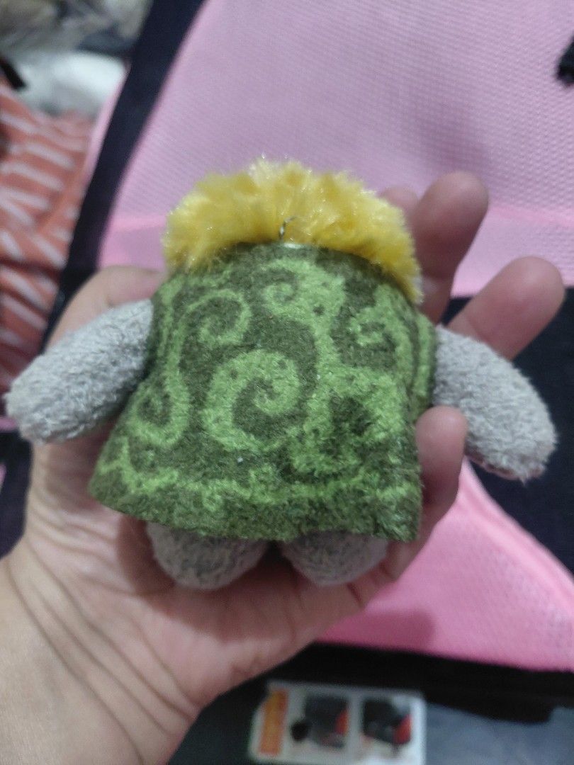 Frozen Troll Plush Keychain (Category: Plushies & Soft Toys) located in Manila. Submitted by bashamylove0116 (Listing ID 1396768652, Image 2). Description: - Frozen Troll plush keychain - Features a grey character - Accented with yellow and green - Character is wearing a green patterned outfit - Includes a metal chain - Small, collectible item.